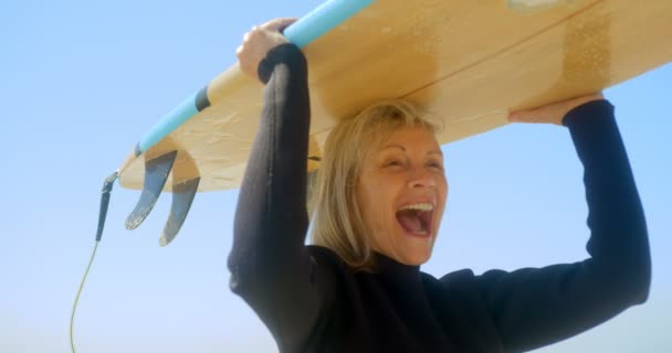 Vista Frontal Surfista Feminina Caucasiana Ativa Carregando Prancha Surf Sua — Vídeo de Stock