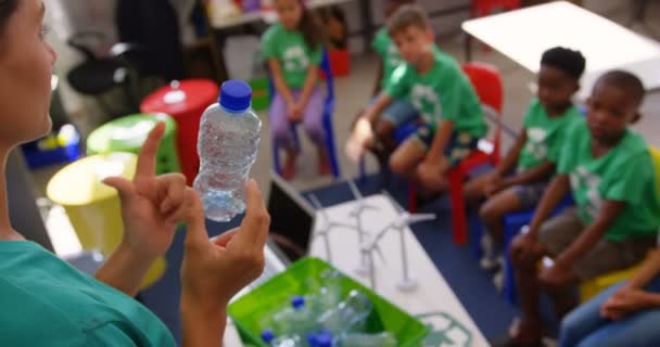 白人女教师在课堂上教小学生关于瓶子回收 他们正坐在教室里 — 图库视频影像