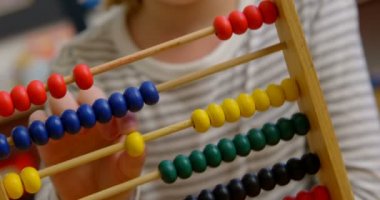 Sınıfta abaküs ile matematik öğrenen Kafkas kız öğrencinin ön görünümü. Boncukları 4k sayıyorum.