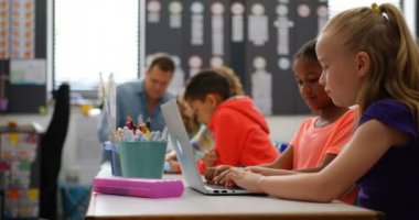 Sınıfta dizüstü bilgisayarda okuyan Karışık ırklı kız öğrencilerin yan görünümü. Sınıfta dizüstü bilgisayarda okuyan Kafkas kız öğrencilerinin Erkek Tarafı görünümü 