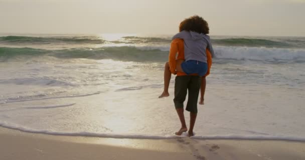 Vista Posteriore Uomo Che Cavalcavia Alla Donna Sulla Spiaggia Stanno — Video Stock