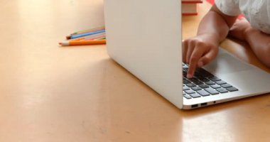 Okulda bir sınıfta dizüstü bilgisayar ile okuyan özenli Asyalı öğrenciyan görünümü. O masada oturuyor 