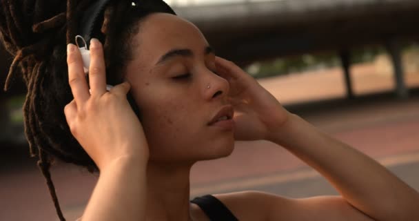 Vista Frontal Una Joven Afroamericana Escuchando Música Los Auriculares Ciudad — Vídeo de stock