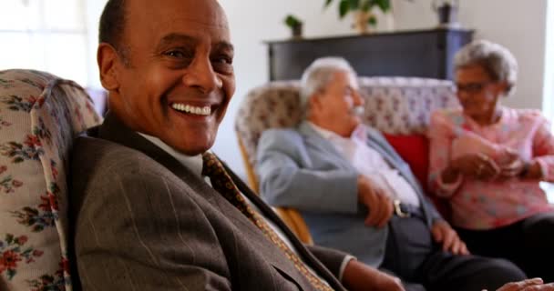 介護施設で交流する人種の先輩たち 先輩笑顔とカメラを見て — ストック動画