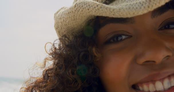 浜辺に立つアフリカ系アメリカ人女性のクローズアップ 彼女は微笑んでカメラ4Kを見ている — ストック動画