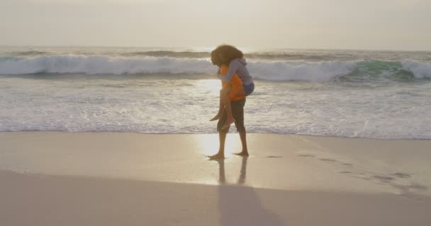 Achteraanzicht Van Mens Geven Piggyback Ride Naar Vrouw Het Strand — Stockvideo