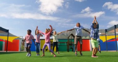 Okul bahçesinde egzersiz yapan melez öğrencilerin ön görüntüsü. Birlikte eğleniyorlar. 4K