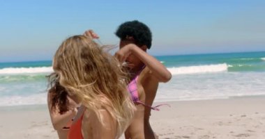 Güneşli bir günde plajda eğlenirken birlikte dans genç çok etnik kadın arkadaşlar Ön görünümü 4k