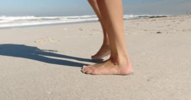 Güneşli 4k plajda yürüyen genç Kafkas kadın Düşük bölümü