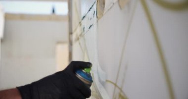 Duvarda aerosol sprey ile kafkas grafiti sanatçısı boyama yan görünümü. O yaratıcı 4k