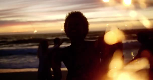 黄昏时分 一群不同朋友在沙滩上玩火花的前方景色 他们有乐趣 — 图库视频影像