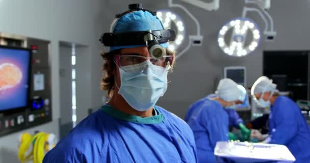 白种女外科医生站在医院手术室前视图 外科医生在后台4K中执行手术 — 图库视频影像
