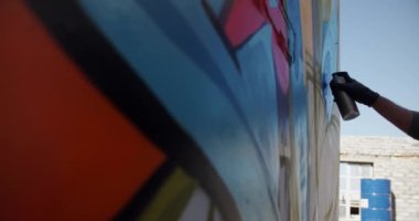 Duvarda aerosol sprey ile kafkas grafiti sanatçısı boyama düşük açı görünümü. O yaratıcı 4k