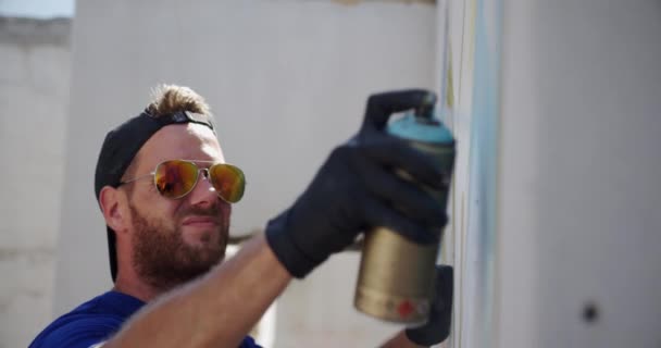 Vista Lateral Pintura Graffiti Caucásico Con Aerosol Pared Lleva Gafas — Vídeo de stock