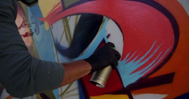 Középső szakasza kaukázusi graffiti művész festés Aeroszolos spray a falon. Ő a kreatív 4k