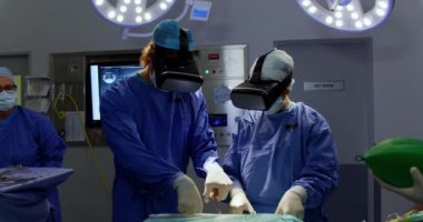Hastanede ameliyat sırasında sanal gerçeklik kulaklığı kullanan cerrahların ön görünümü. Birbirleriyle etkileşime giriyorlar 4k