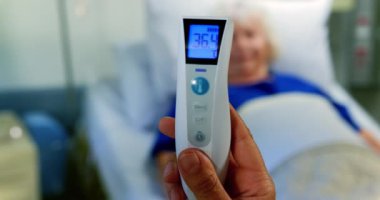 Hastanede 4k arka planda beyaz hasta ile cerrah tarafından tutulan termometre tutma yakın