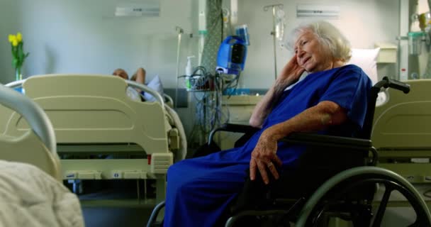 在医院病房里坐在轮椅上的现役白种人老年病人的侧面视图 她紧张和担心4K — 图库视频影像