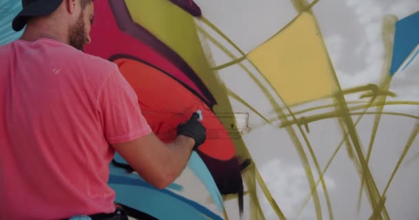壁にエアロゾルスプレーで描いた白人落書きアーティストの背面図 彼は創造的な4Kです — ストック動画