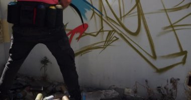 Duvarda aerosol sprey ile kafkas grafiti sanatçısı boyama arka görünümü. O yaratıcı 4k