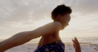 Sahilde el ele koşan Afro-Amerikan çiftin düşük açı görüntüsü. Onlar eğlenceli 4k yaşıyorsanız