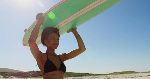 Vista Bajo Ángulo Joven Surfista Afroamericana Sonriendo Llevando Tabla Surf — Vídeos de Stock