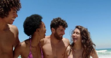 Güneşli 4k eğlenirken sahilde ayakta kol ile genç çok etnik arkadaş Ön görünümü
