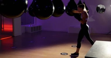 Fitness stüdyosunda boks yapan Kafkas kadın boksörün yan görünümü. O kararlı ve 4k odaklanmış