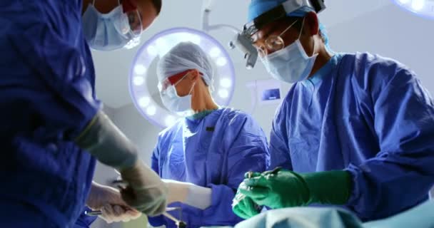病院4Kの手術劇場で手術を行う多民族外科医の正面図 — ストック動画