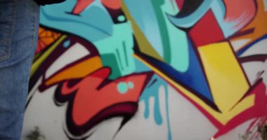 Koruyucu maske tutan Kafkas grafiti sanatçısının orta bölümü. O grafiti duvar 4k önünde duruyor