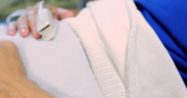 Hastanenin koğuşundaki yatakta dinlenen beyaz erkek hastaya yakın çekim. 4k 'ı kaçırıyor.