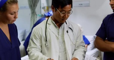 Hastanede birbirleriyle etkileşime giren çok ırklı tıp ekibinin ön görüşü. Üst düzey hasta arka planda dinleniyor.