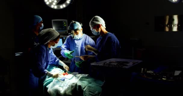 Frontansicht von Chirurgen, die im Operationssaal des Krankenhauses operieren. Chirurgen halten chirurgische Instrumente in der Hand
