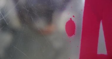 Cam duvara grafiti sanatçısı sprey boya yakın çekim. Kırmızı sprey boya 4k kullanarak yaratıcı sanatçı