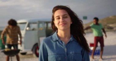 Sahilde duran Beyaz kadının ön görünümü. Arkadaşlar arka planda 4k eğleniyor