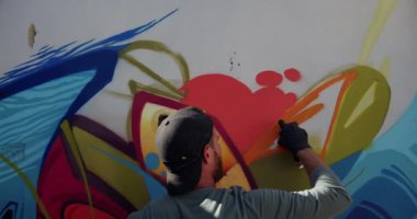 Duvarda aerosol sprey ile kafkas grafiti sanatçısı boyama arka görünümü. O yaratıcı 4k