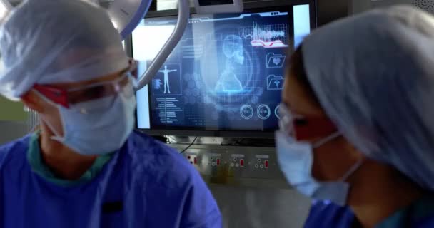 病院の手術劇場で手術を行う多民族外科医の正面図 彼らはお互いに相互作用している4K — ストック動画