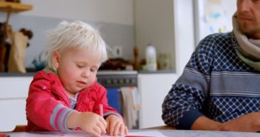 Beyaz baba evde çizim kızı yardım ön görünümü. Oğlu çizimini gösteriyor. 4k