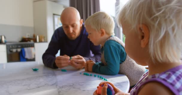 快適な家で粘土と一緒に遊ぶ白人の父と子供の正面図 テーブル4Kに座っている — ストック動画