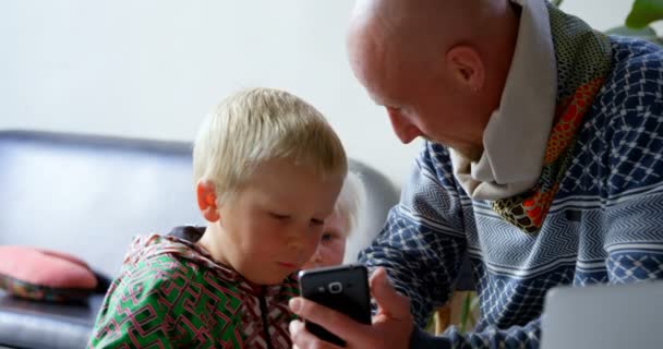 Vooraanzicht Van Kaukasische Vader Zoon Met Behulp Van Mobiele Telefoon — Stockvideo