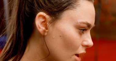 Fitness stüdyosunda duran yorgun güzel Beyaz kadın yan görünümü. Terini siliyor. 4k