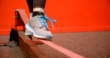 Fitness stüdyosunda dengeleme egzersizi yapan Beyaz kadının kapalı-up. Kararlı ve odaklanmış durumda. 4k