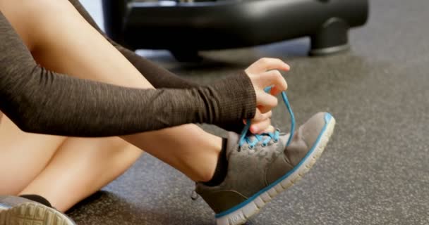 Vista Lateral Hermosa Mujer Caucásica Atando Cordones Gimnasio Ella Está — Vídeo de stock