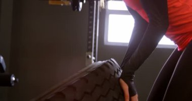 Bir fitness stüdyosunda egzersiz kararlı güzel Kafkas kadın Yan görünümü. Lastik kullanıyor. 4k