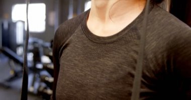 fitness stüdyosunda elinde jimnastik yüzükleri tutan güzel beyaz bir kadının yan görüntüsü. Egzersiz için hazır. 4k