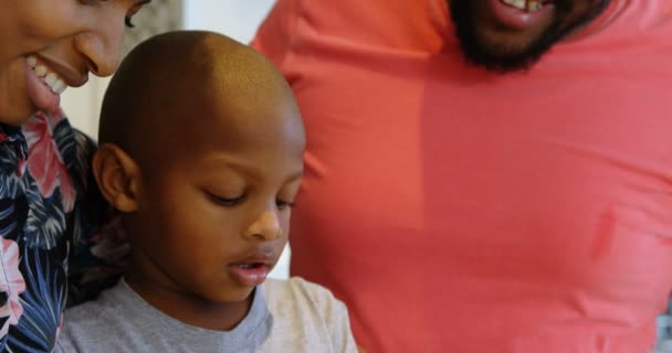 非洲裔美国人的父母和儿子在家里的厨房准备食物的正面视图 他们正在教他们的儿子 — 图库视频影像