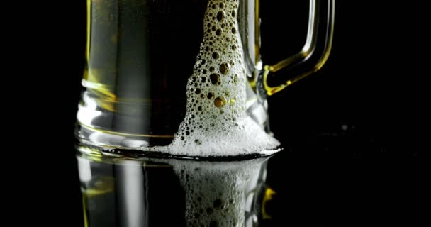 Close Caneca Cerveja Contra Fundo Preto Espuma Cerveja Transbordando Copo — Vídeo de Stock