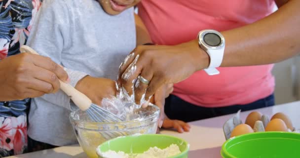 美国黑人父亲和儿子往碗里倒面粉 母亲在搅拌鸡蛋 他们在准备食物 — 图库视频影像