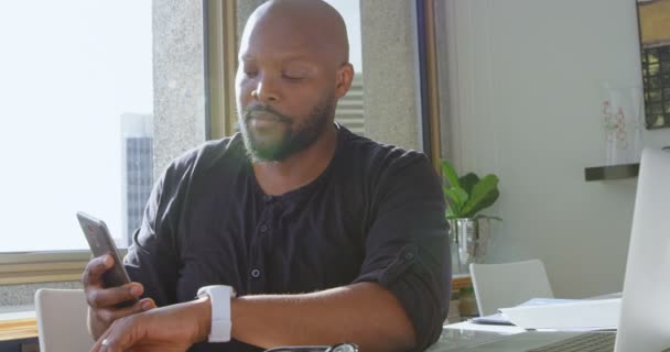 Vista Frontal Del Hombre Afroamericano Usando Smartwatch Teléfono Móvil Hogar — Vídeo de stock