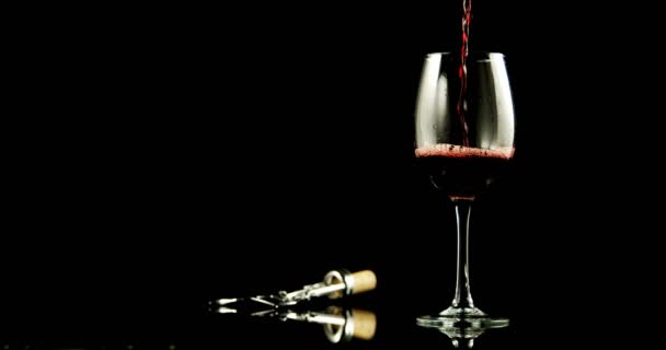 Víno z červeného skla, které se Nalévalo na černé pozadí. Křídlový šroub vedle skleněného vína. 4k